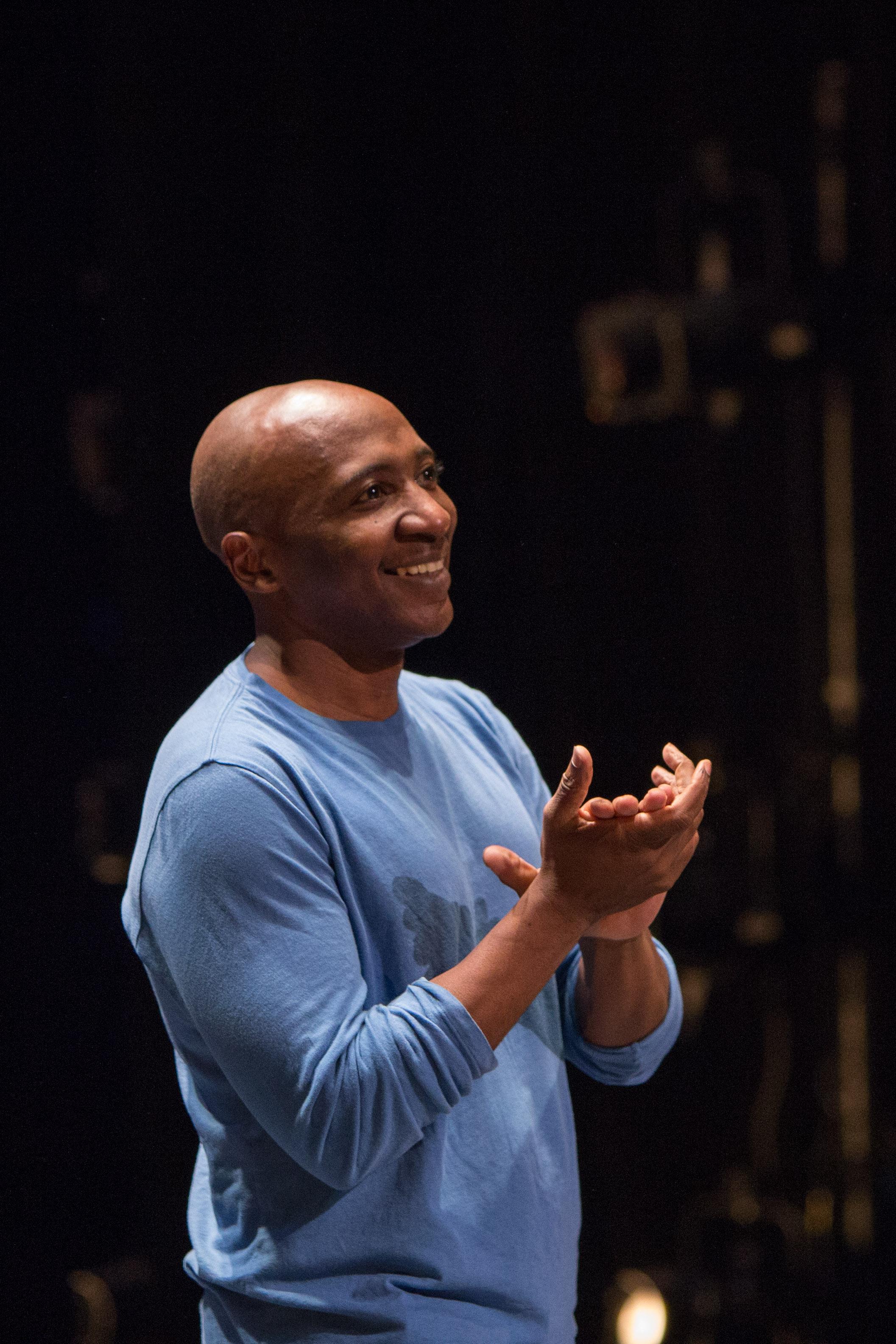 Choreographer Frederick Earl Mosley smiling and clapping his hands in a rehearsal