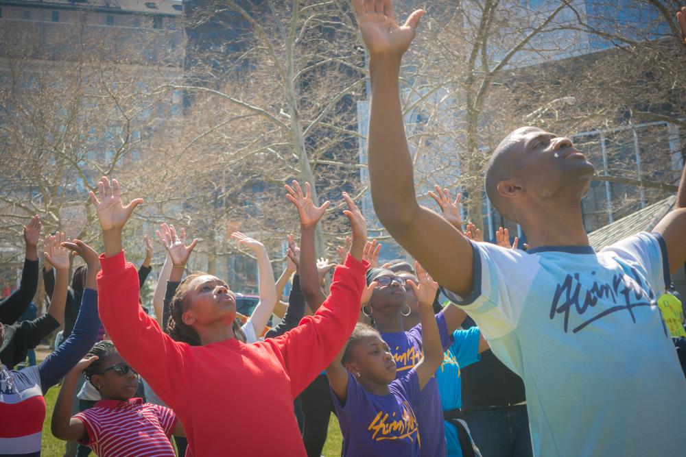 Crowd of dancers with arms lifted to the sky