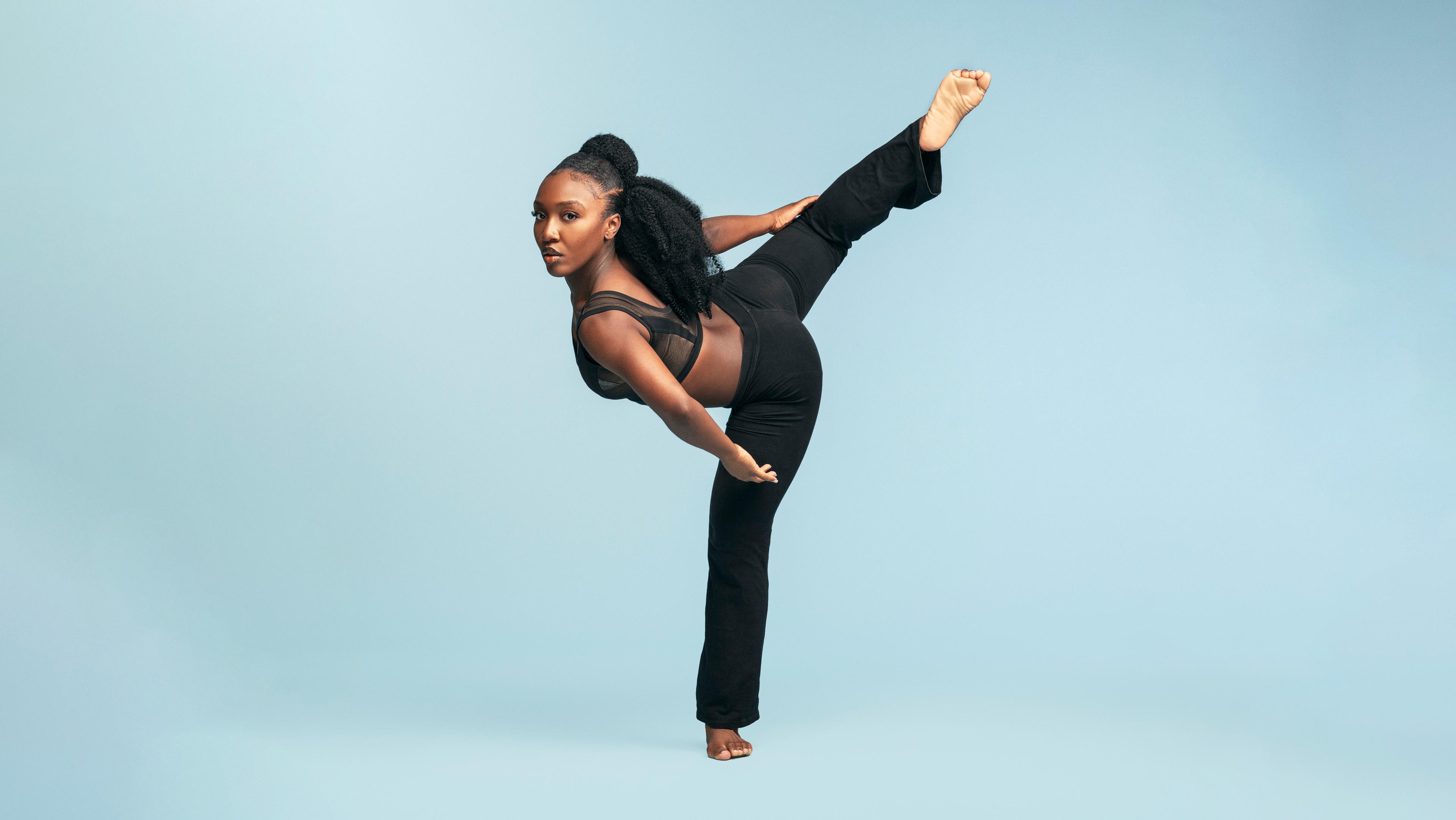 Female dancer wearing black with leg extended to the back