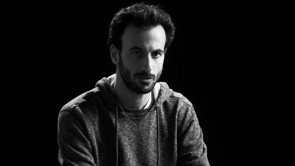 A black and white image of a man in a hoodie.