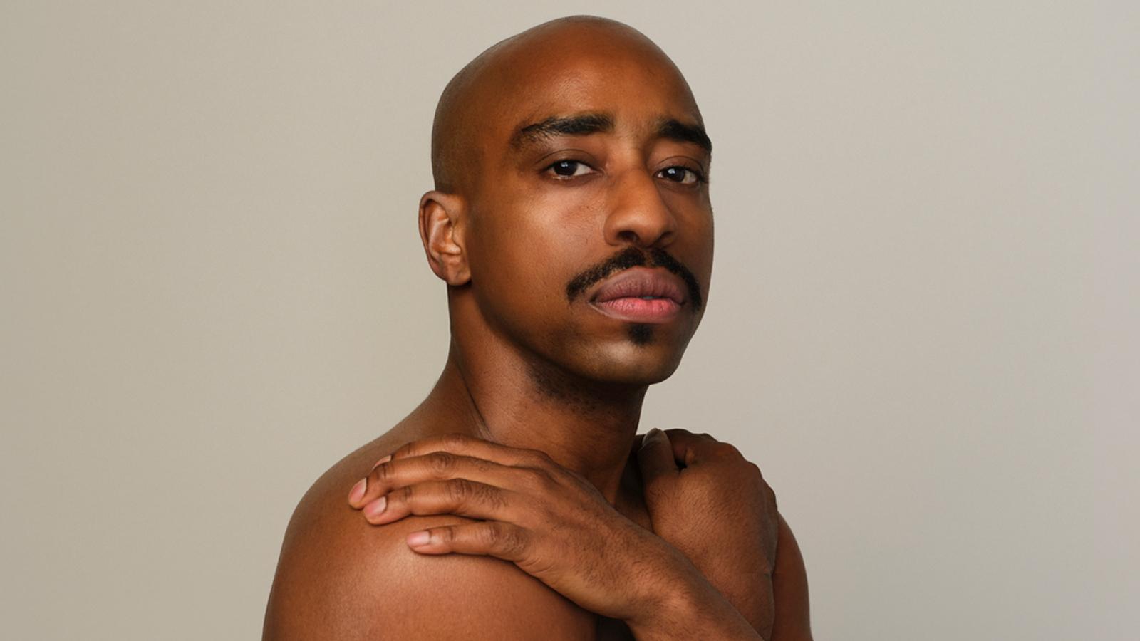 Portrait of Renaldo Maurice, a male dancer with a mustache and one hand on his shoulder