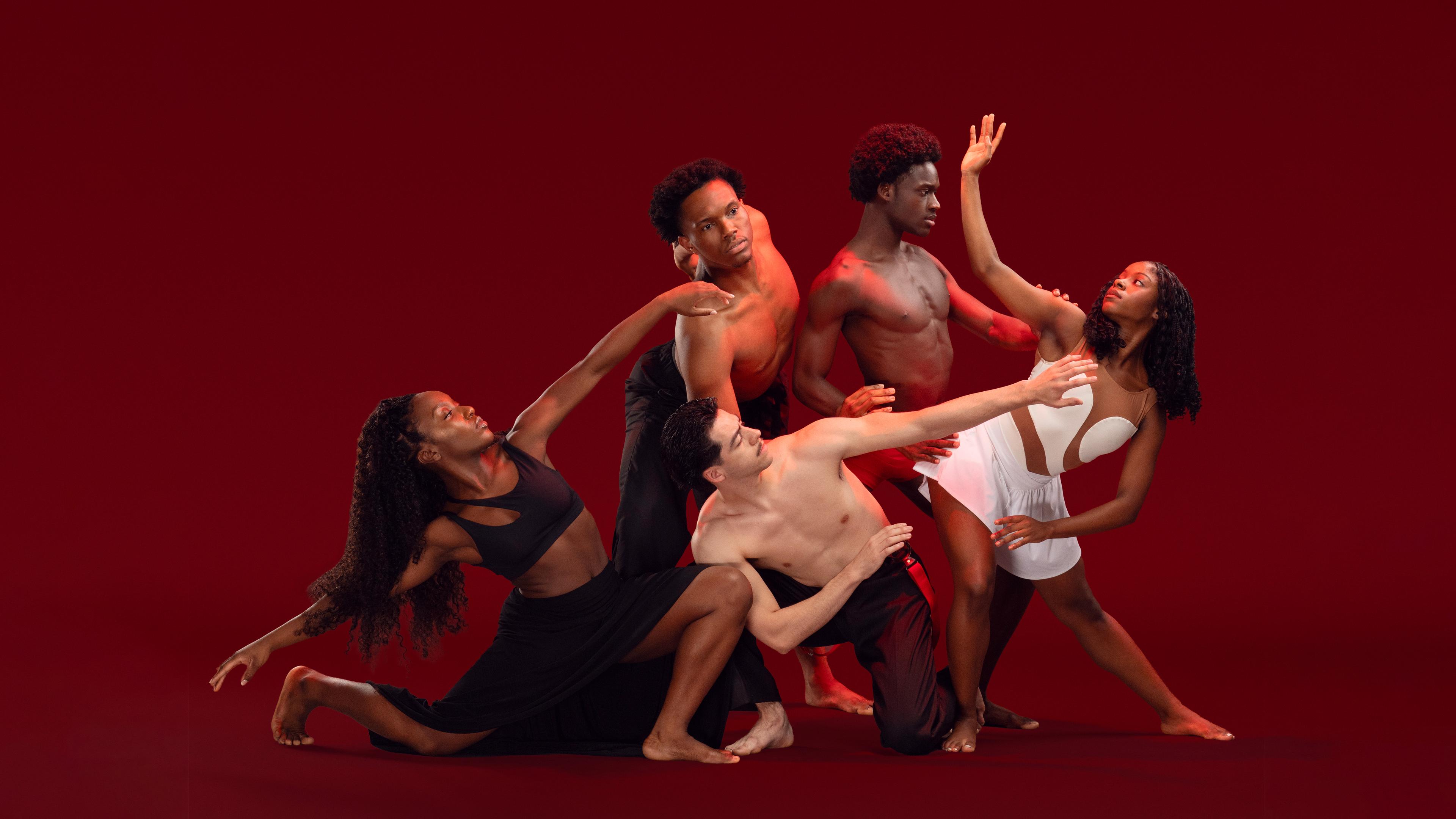 Ailey II dancers in a group in various poses in front of a red background